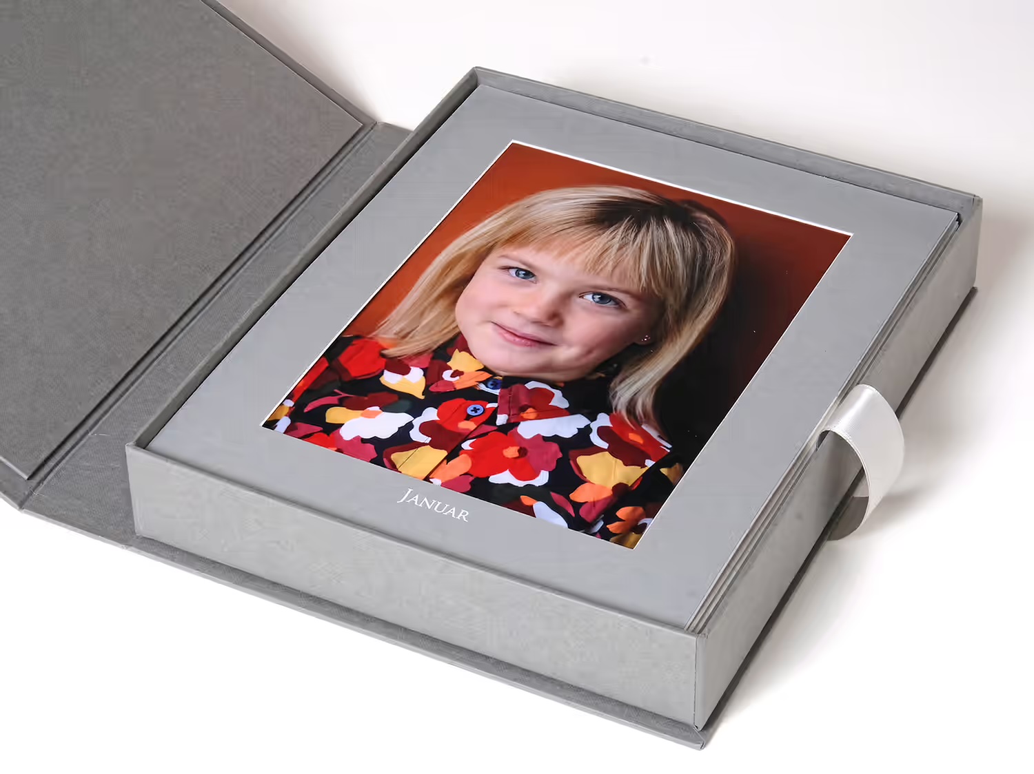 Präsentationsbox aus grauem Leinen mit Kinderportrait im Passepartout